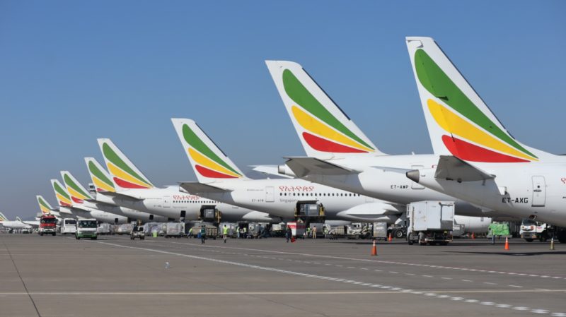 a row of airplanes parked on a runway