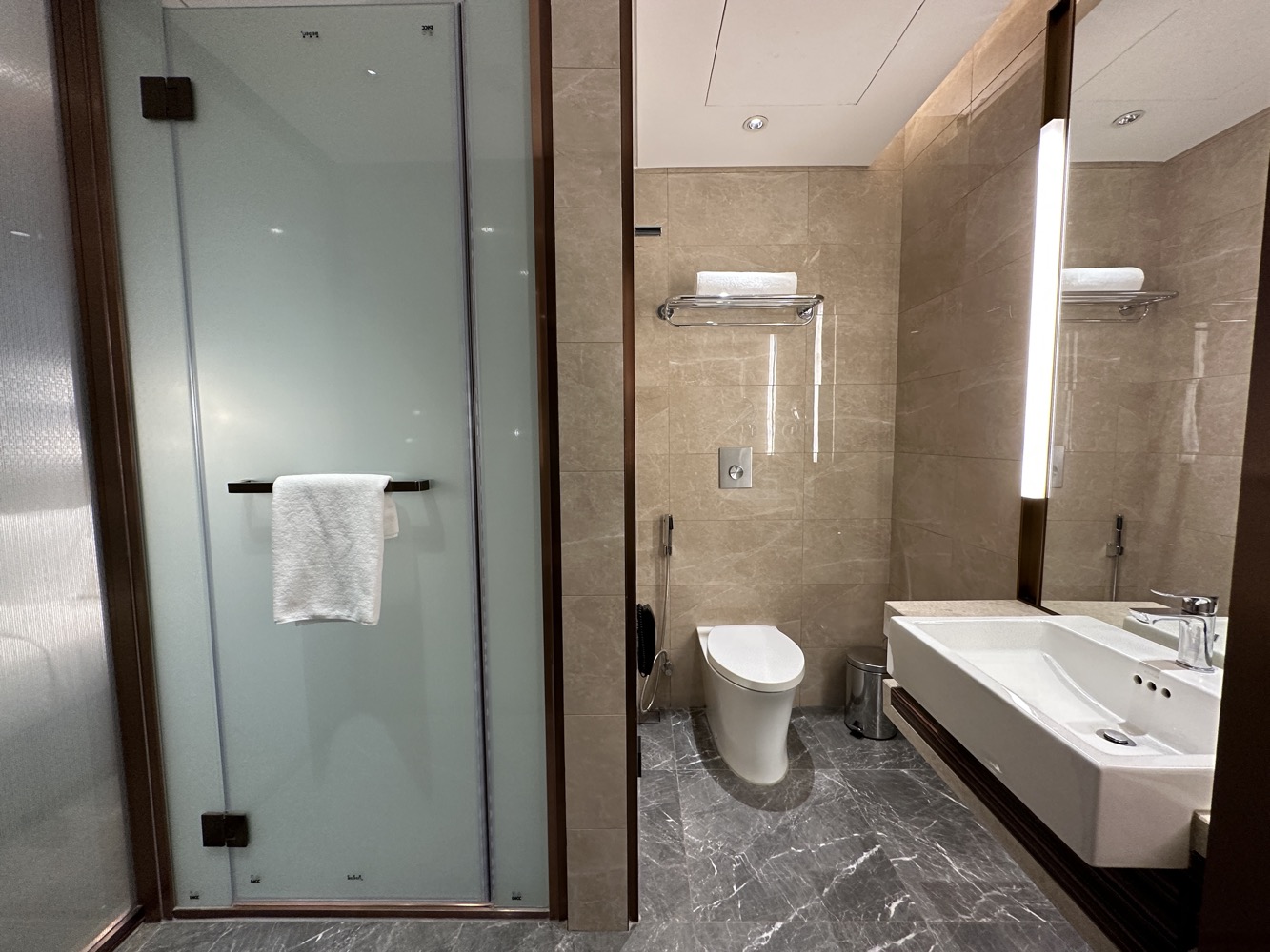 a bathroom with a glass shower door and toilet