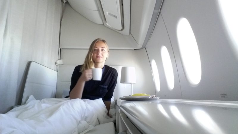 a woman sitting in a bed with a cup of coffee