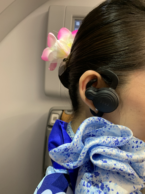 a woman wearing a blue and white scarf with a flower in her hair