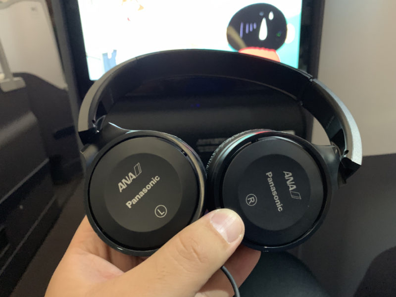 a hand holding a pair of headphones