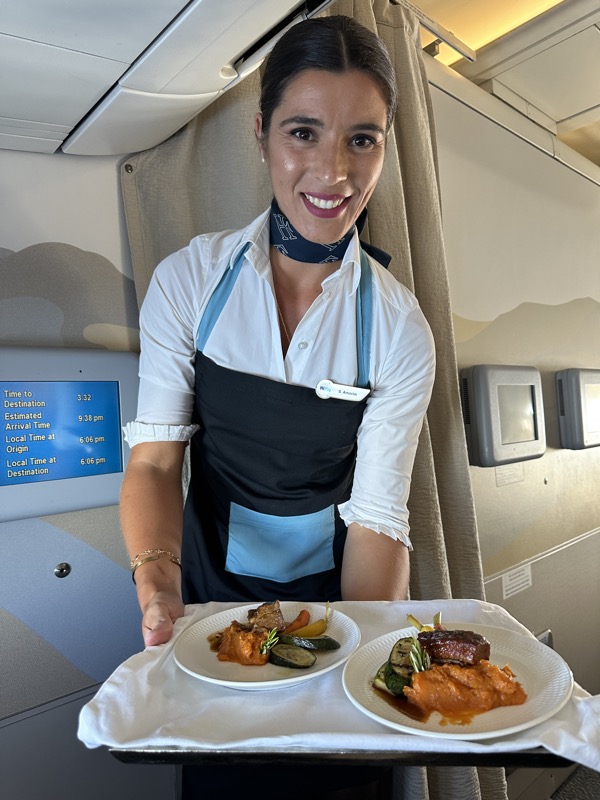 a woman wearing an apron and holding plates of food