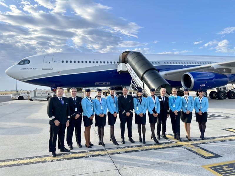 a group of people in uniform standing in front of an airplane