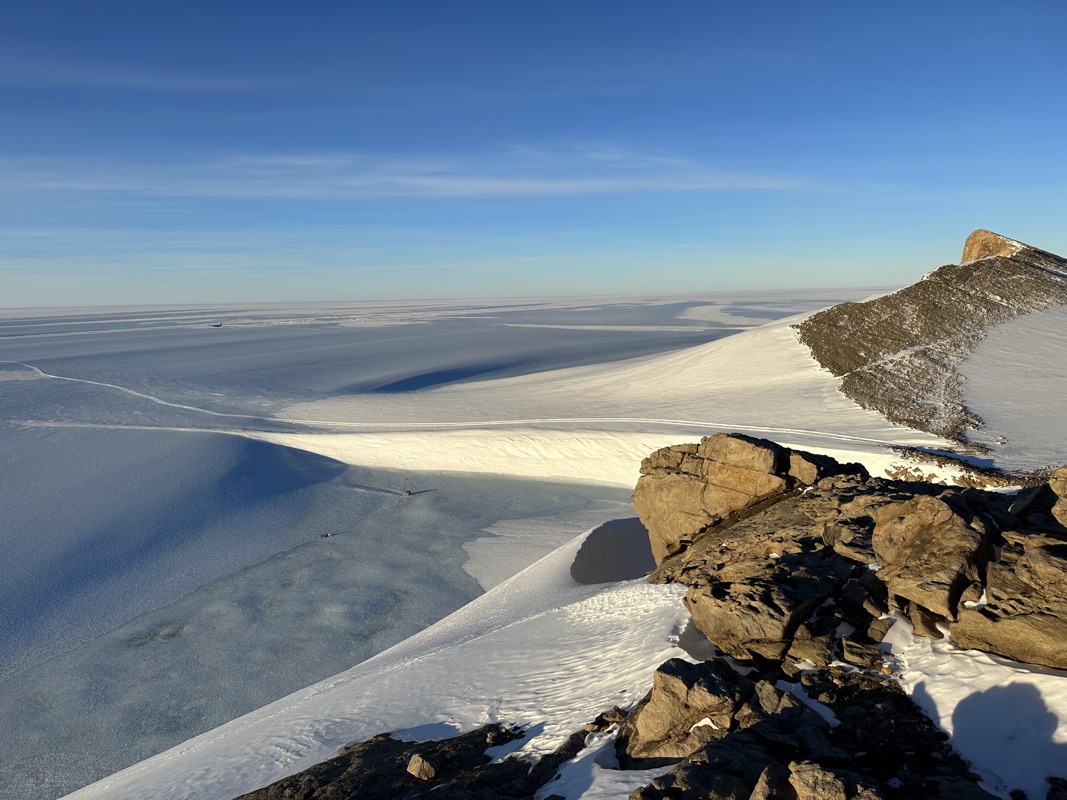 a snowy landscape with rocks and a body of water