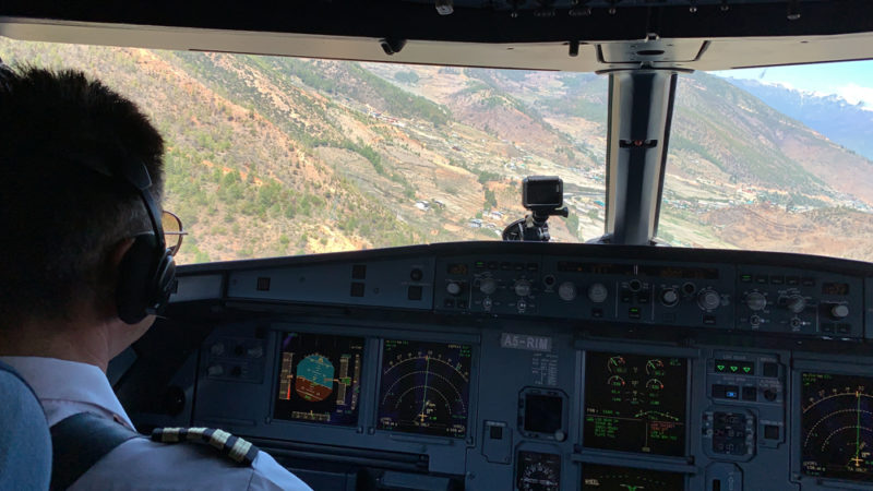 a cockpit of an airplane with a view of the mountains