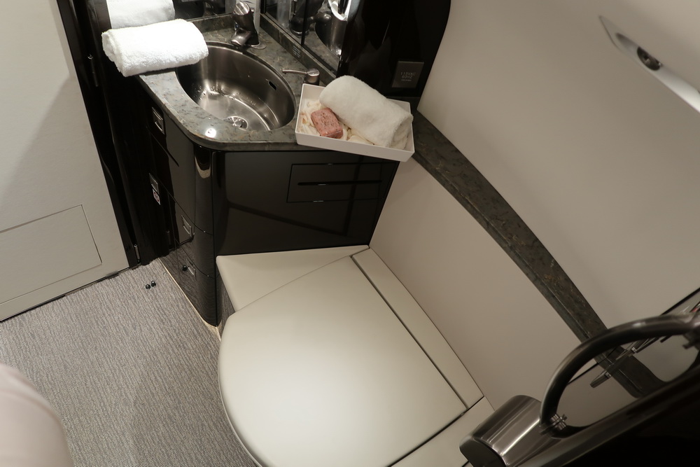 a toilet and sink with towels on it