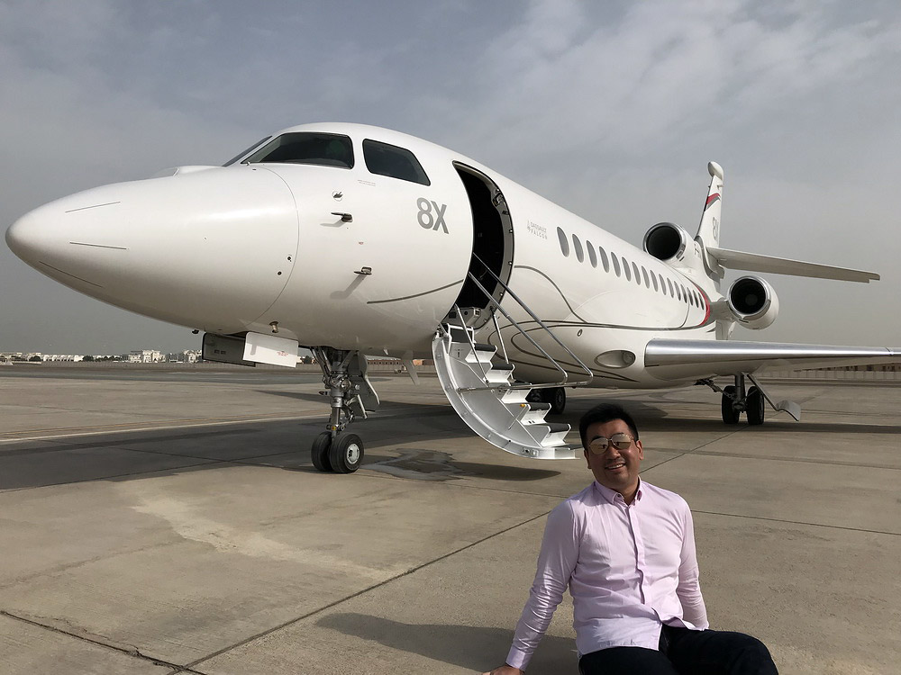 a man sitting on the ground next to an airplane