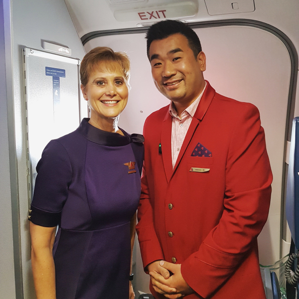 a man and woman standing in an airplane