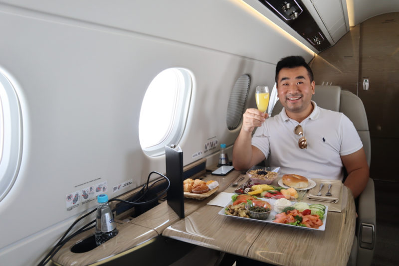 a man sitting at a table with food and drink