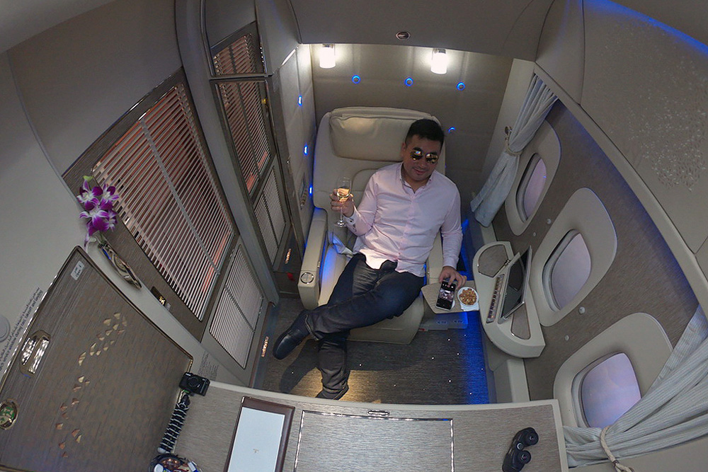 a man sitting in a chair with a drink and a plate of food