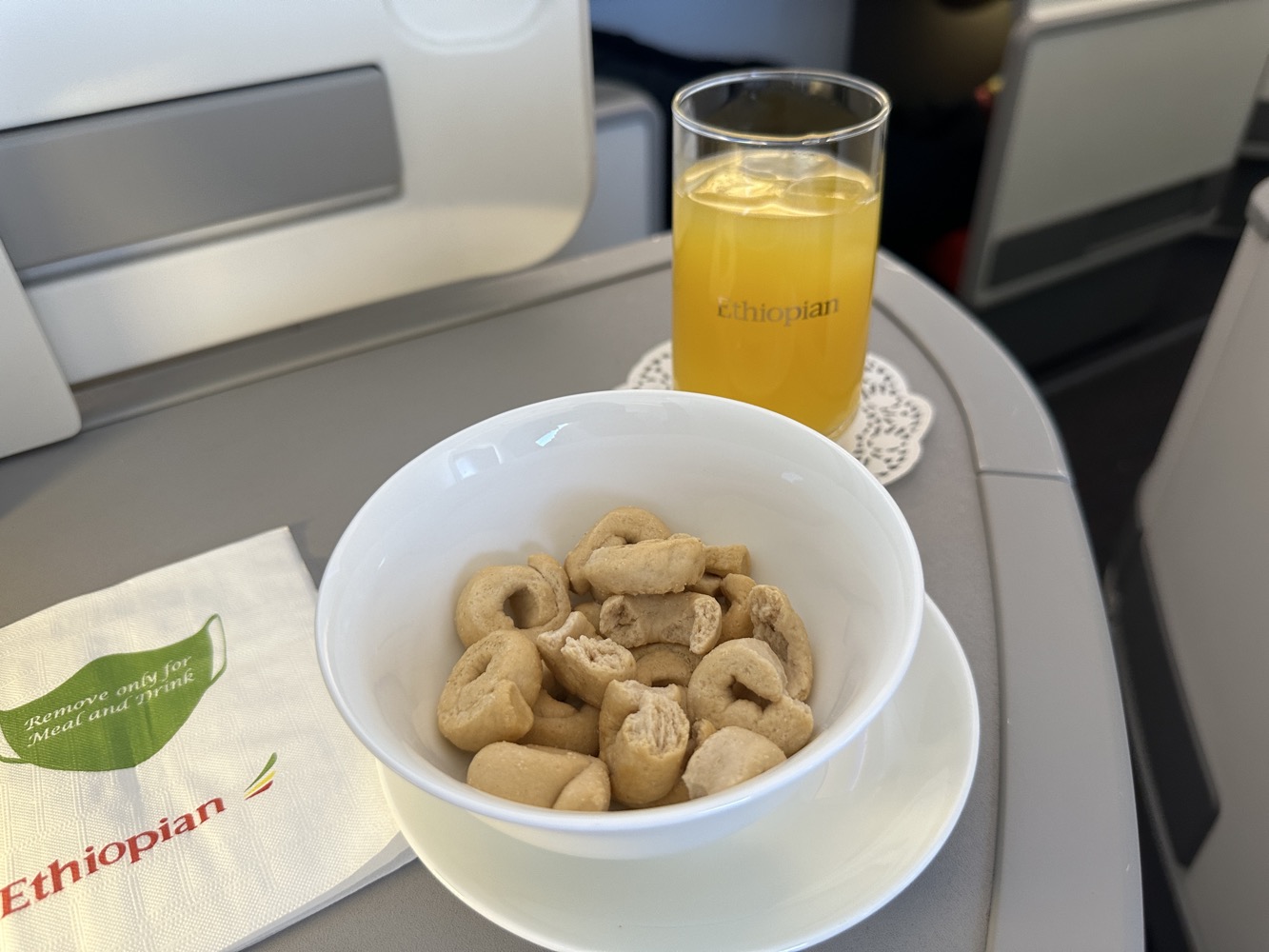 a bowl of cereal and a glass of orange juice on a table