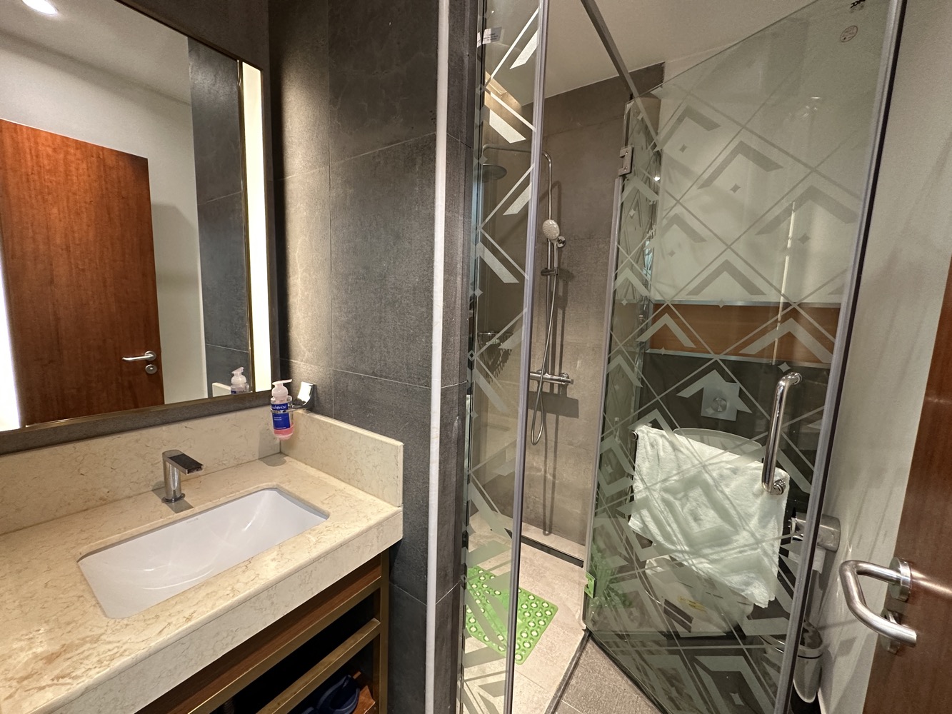 a bathroom with a glass shower door and sink