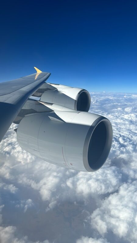 a plane wing with clouds in the background