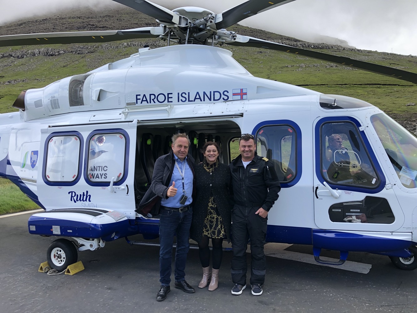 a group of people standing in front of a helicopter