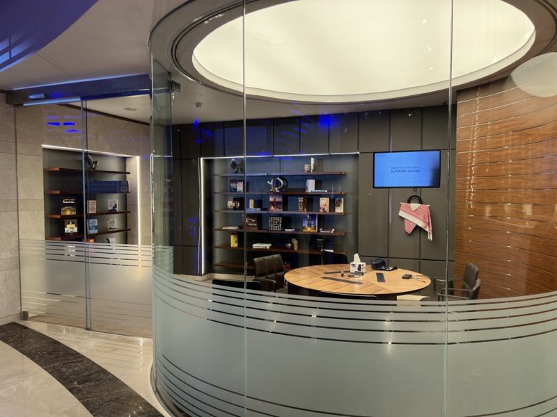 a glass wall with a round table and a desk