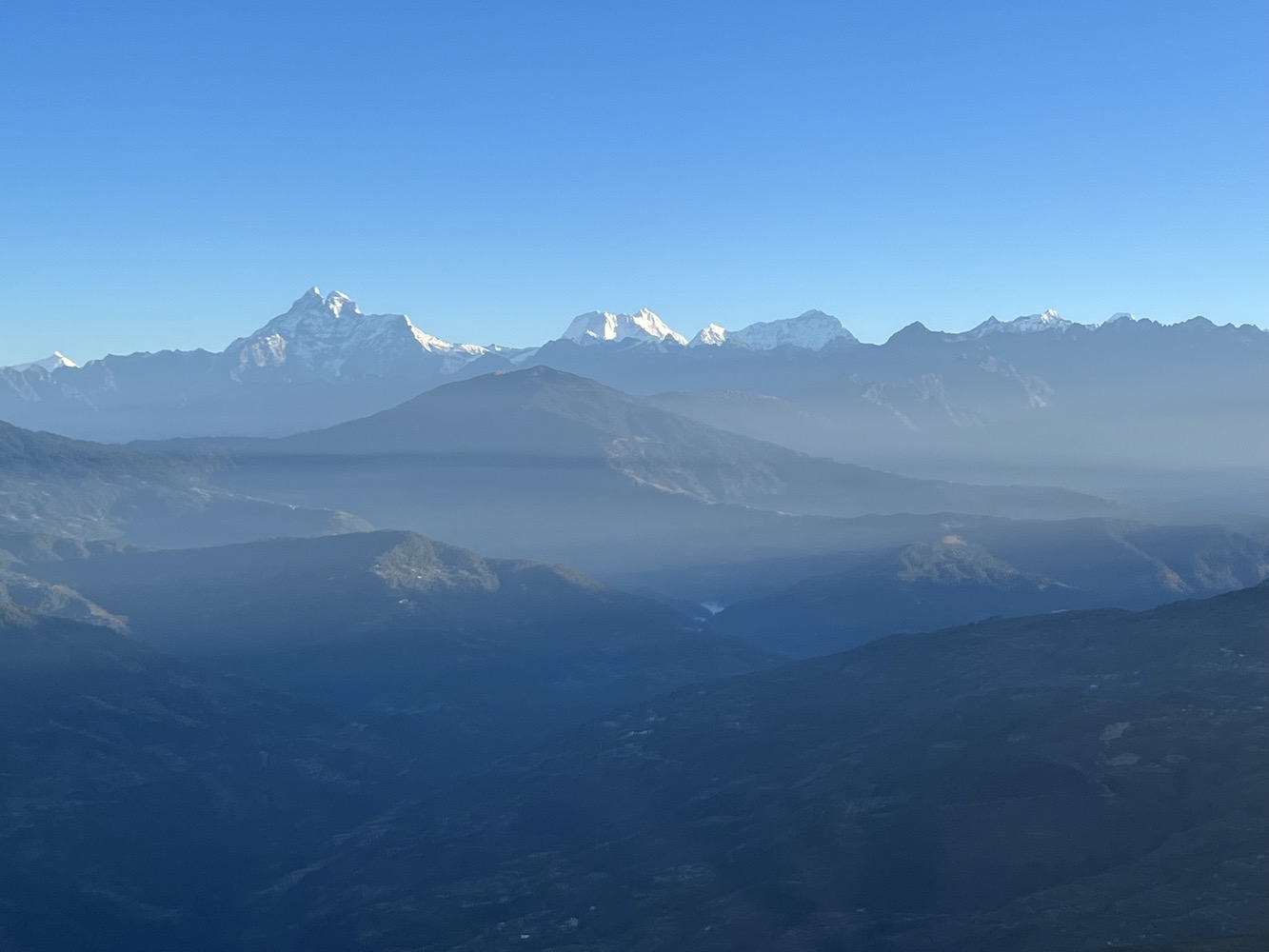 a mountain range with snow capped mountains in the background