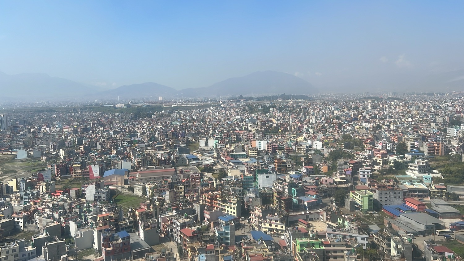 a city with many buildings and a mountain in the background