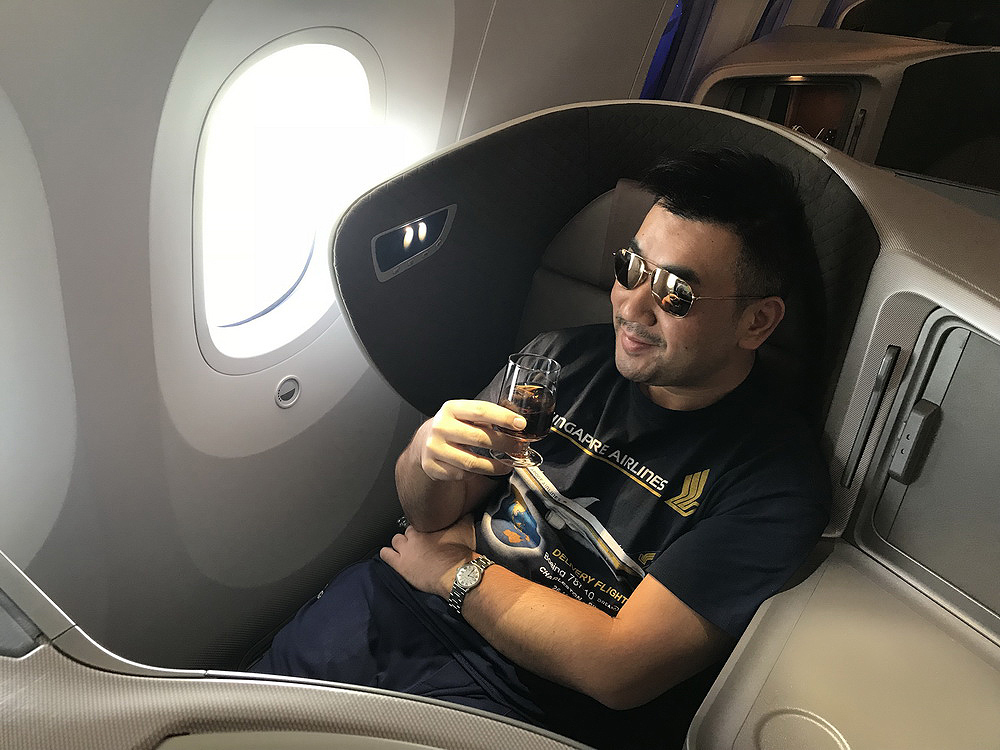 a man sitting in a chair with a glass of wine