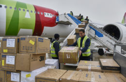 a group of people loading boxes into an airplane