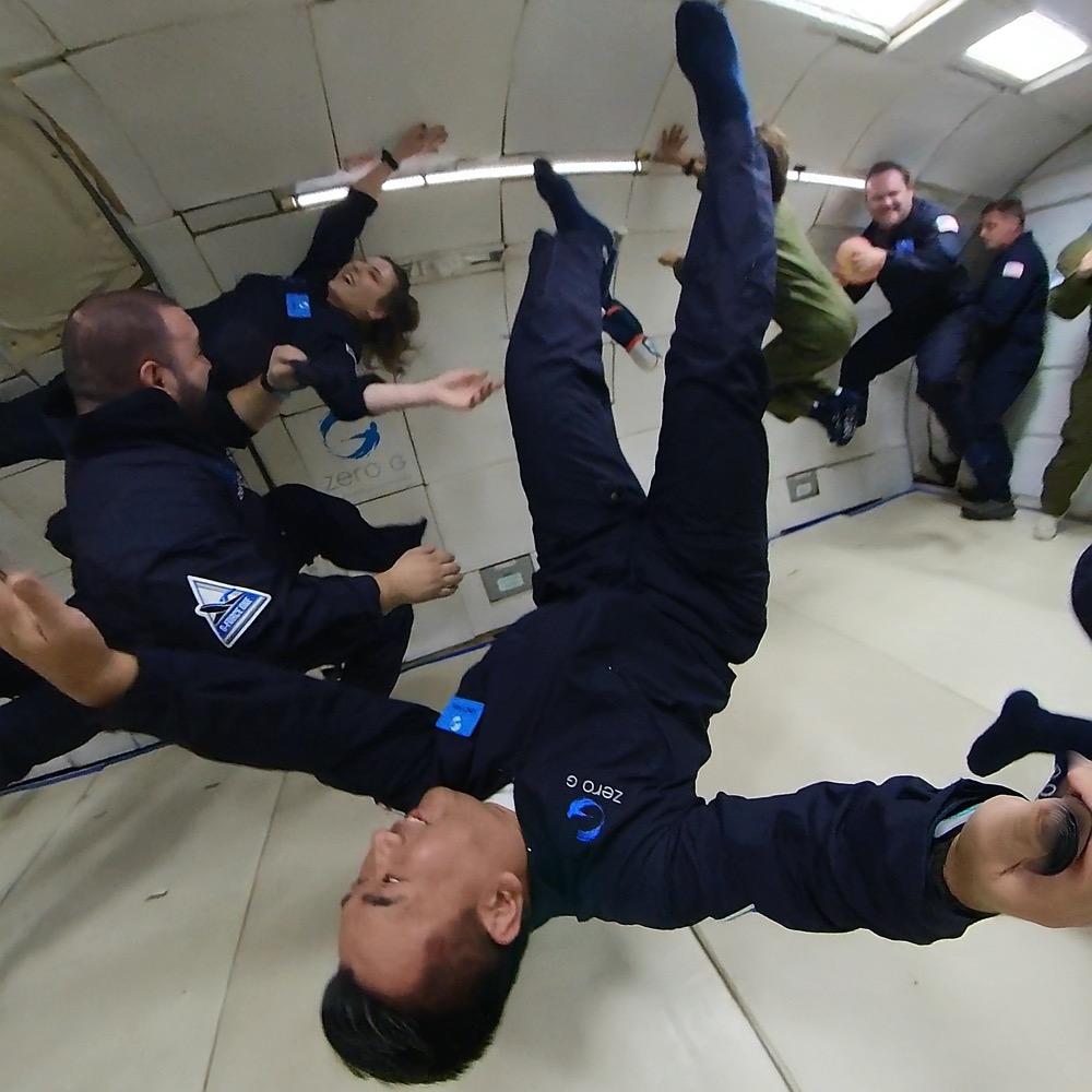 a group of people in a room with a man in the air